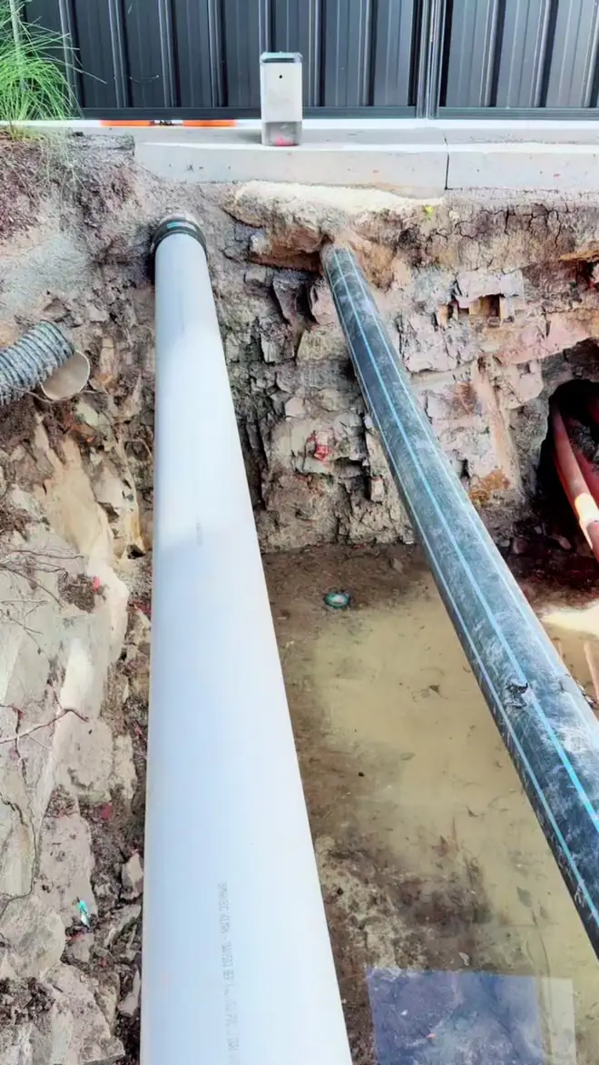 White PE conduit laid in an excavated pit in Canberra.