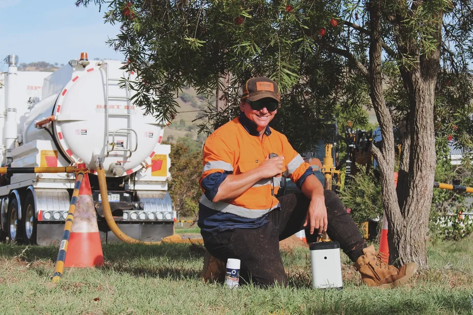 Spot On crew member taking a break beside a hydrovac truck.